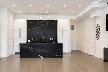 3535 Venue main room with a black marble kitchen island and a wall-mounted TV