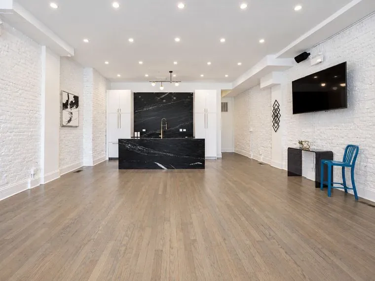 3535 Venue main room with a black marble kitchen island and a wall-mounted TV