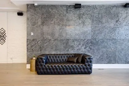 Black leather sofa by the stone accent wall at 3535 Venue in Humboldt Park
