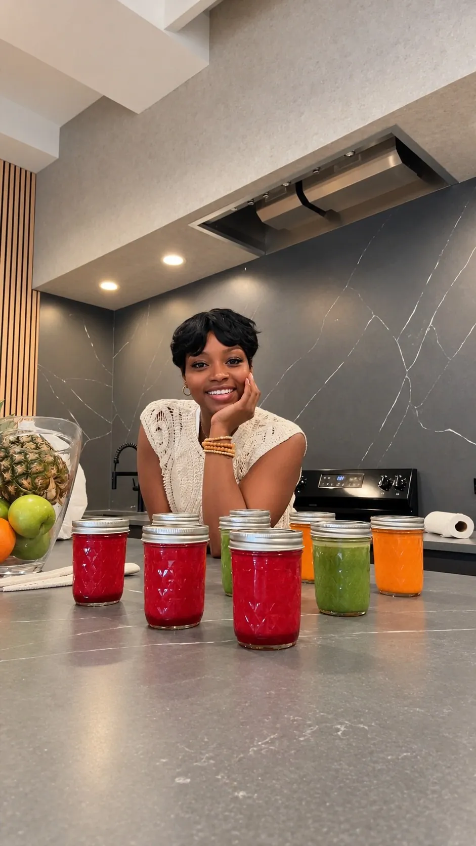 Guest with colorful juice jars at the marble kitchen island