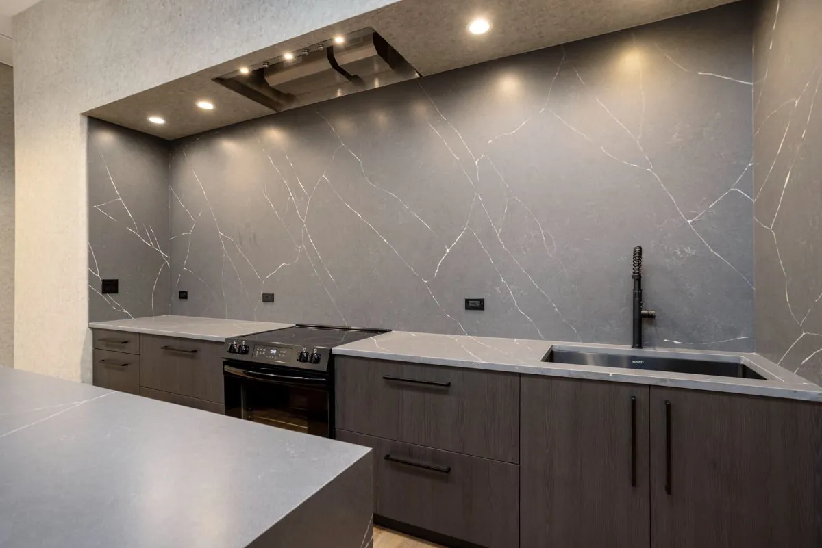 Kitchen counters with electric range, sink, and marble backsplash