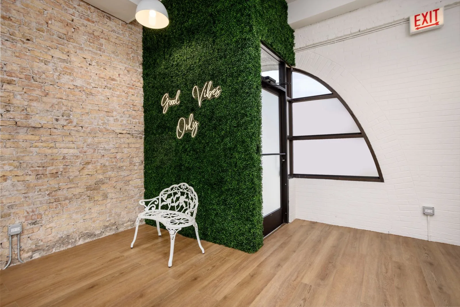 Neon sign and white garden bench by the arched window