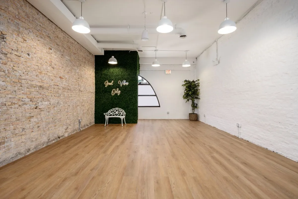 Open floor facing the arched window and exposed brick