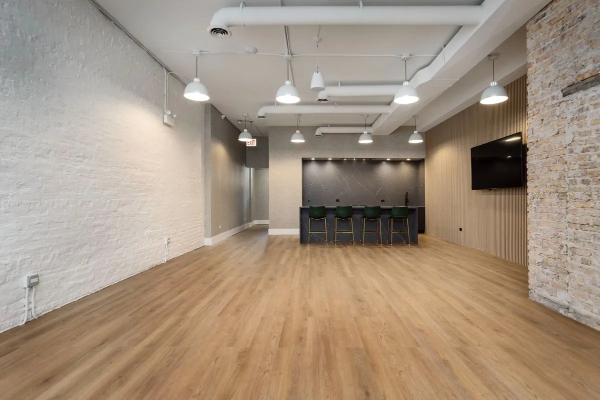 Open floor toward the kitchen island and wall-mounted TV