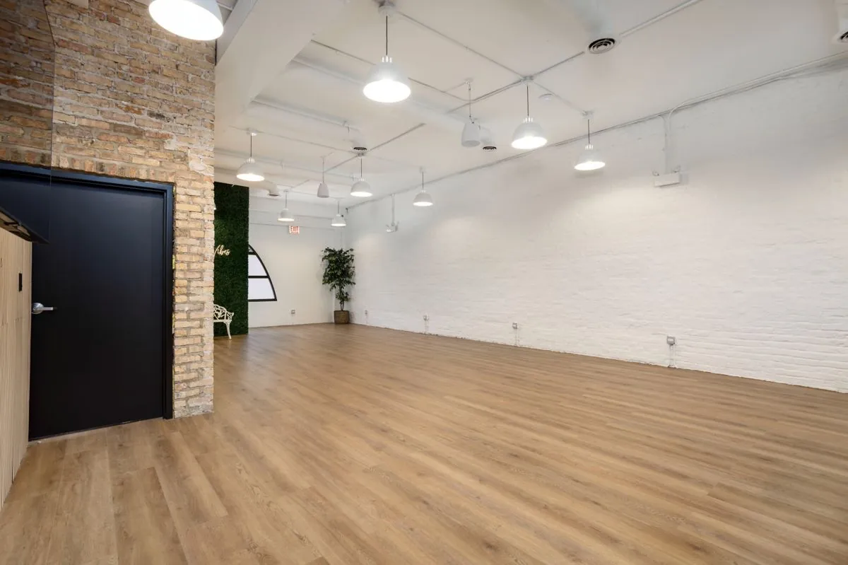 Open event space with white brick walls and pendant lighting