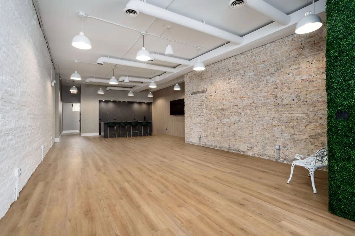 Open floor toward the kitchen, between the white brick and exposed brick walls