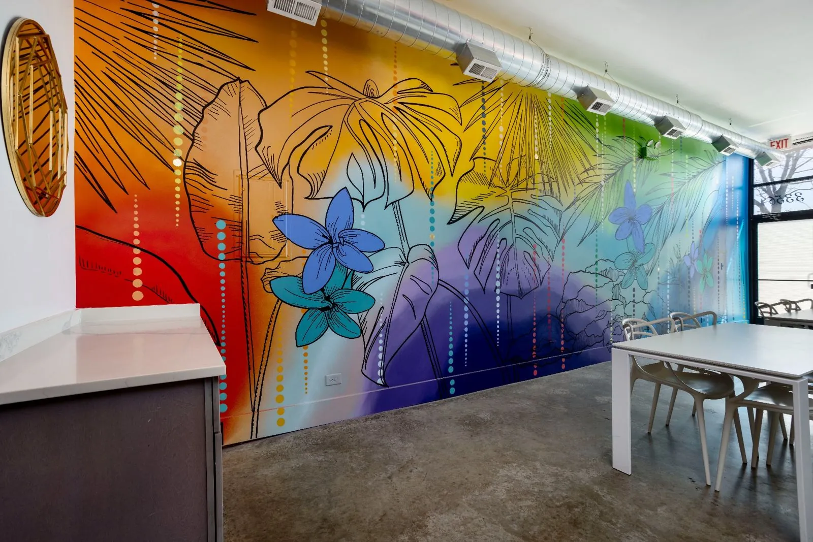 Tropical mural in orange, yellow, green, and purple along the side wall