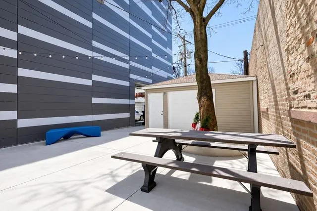 Private outdoor courtyard with a picnic table and string lights at 3535 Venue in Humboldt Park